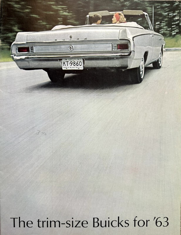 IMG_5584 | Merrick Auto Museum Rear view of a white 1963 Buick convertible driving on a road with two passengers in the back seat, license plate KT-9860.