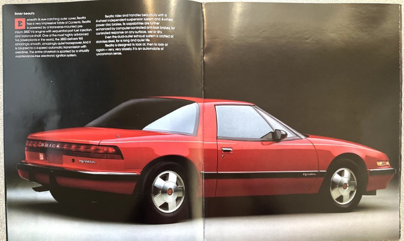 IMG_5654 | Merrick Auto Museum Red Buick Reatta coupe shown in a left/right two-page spread, facing right, on a dark studio backdrop to highlight its profile.