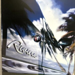 Close-up of a shiny Buick Riviera car door reflecting palm trees, with 'Riviera by Buick' at the top.