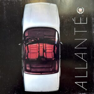 Top-down view of a silver car with red leather seats, seen from above on a dark surface; word 'ATLANTE' appears vertically on the right.