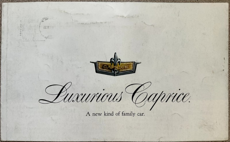 IMG_5905 | Merrick Auto Museum Vintage advertisement card for 'Luxurious Caprice' with a gold-winged Caprice emblem and the tagline 'A new kind of family car.'