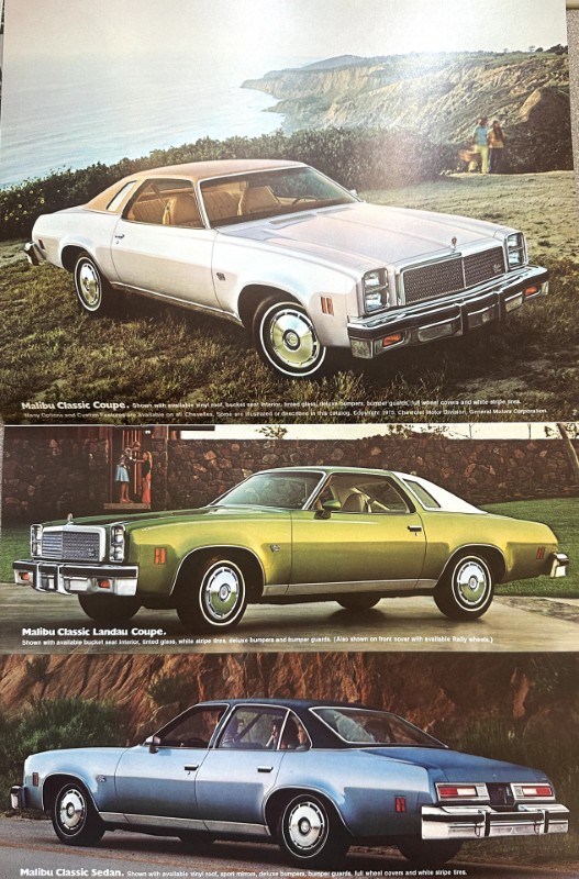 IMG_5990 | Merrick Auto Museum Three classic Malibu cars (white coupe, green landau, blue sedan) parked on a cliff overlooking the ocean, from an outdoor brochure spread.