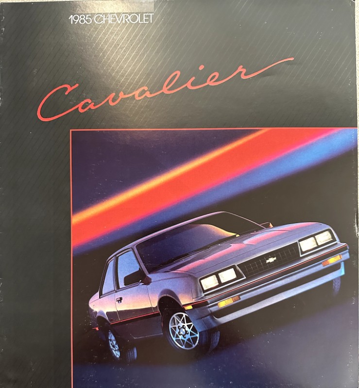 IMG_6101 | Merrick Auto Museum 1985 Chevrolet Cavalier brochure cover with red cursive 'Cavalier' and a tilted image of a silver car against neon light streaks
