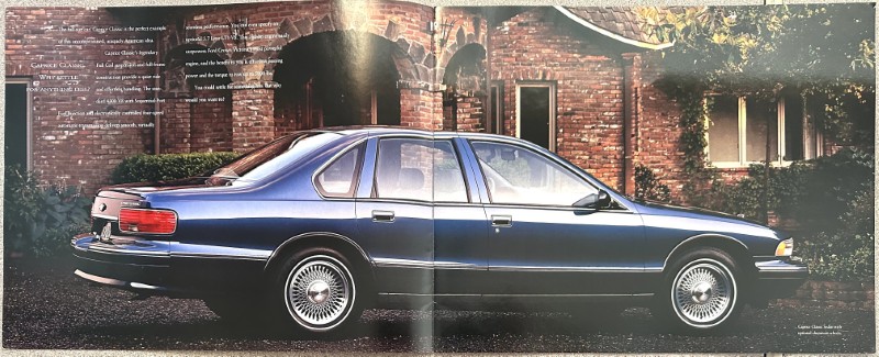 IMG_6162 | Merrick Auto Museum Blue four-door sedan parked on a driveway in front of a brick house.