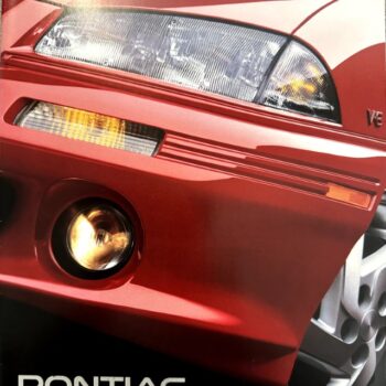 Close‑up of a red Pontiac front end showing the headlight, bumper, and wheel with the slogan 'Pontiac 1994. We are driving excitement.'