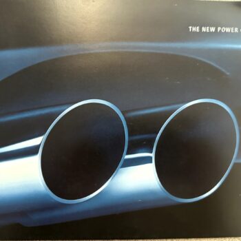Close-up of chrome dual exhaust pipes on a Pontiac car with the slogan 'The New Power of Pontiac 2004' in the corner.