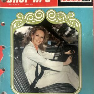 Smiling woman sits in a car seat, hands on the steering wheel, on a vintage 'Shop Tips' magazine cover (May 1977).