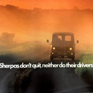A truck driving on a rural road at sunset with the slogan: 'Sherpas don't quit, neither do their drivers.'