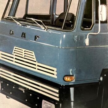 Blue DAF truck cab front view with prominent grille, windshield wipers, and model badge reading 'DAF F 1800' visible on the lower front. Includes orange turn signals and a large black bumper.