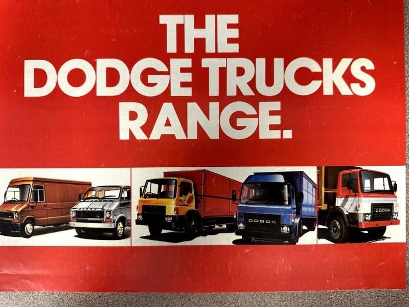 IMG_7355 | Merrick Auto Museum Advertisement banner with bold white text 'THE DODGE TRUCKS RANGE' and lineup of colorful Dodge trucks below.