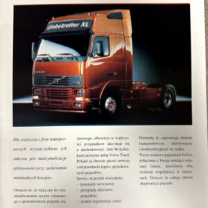 Orange Volvo truck photographed on a brochure page titled 'Volvo Truck Poland' with Polish text columns nearby.