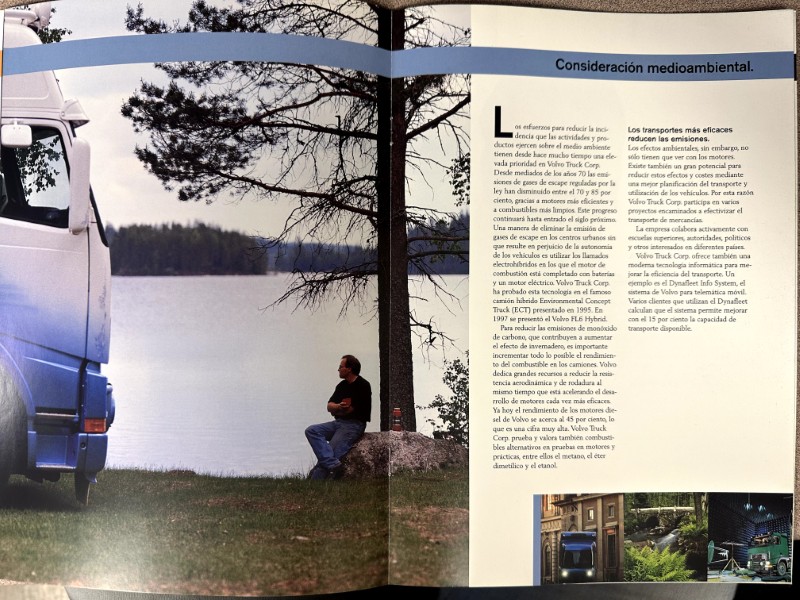 IMG_8693 | Merrick Auto Museum Two-page magazine spread: left page shows a blue truck beside a lake with a man sitting on a rock by a tree; right page has an article titled 'Consideración medioambiental' with column text and small photos at the bottom.