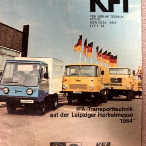 Cover of Kraftfahrzeugtechnik 8/84 featuring blue and yellow IFA trucks parked with flags at the Leipziger Herbstmesse 1984, KFT logo and publisher text in the top right.