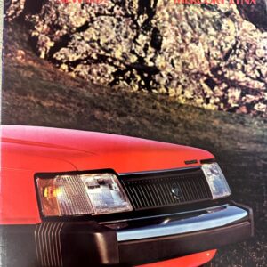 Close-up front view of a red Mercury Lynx car against a rocky background with 1985 styling text at the top