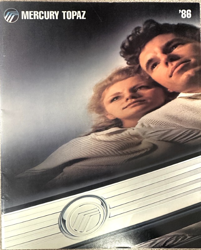 IMG_9058 | Merrick Auto Museum Mercury Topaz '86 brochure cover showing a man and woman leaning on a silver car with Mercury emblem.