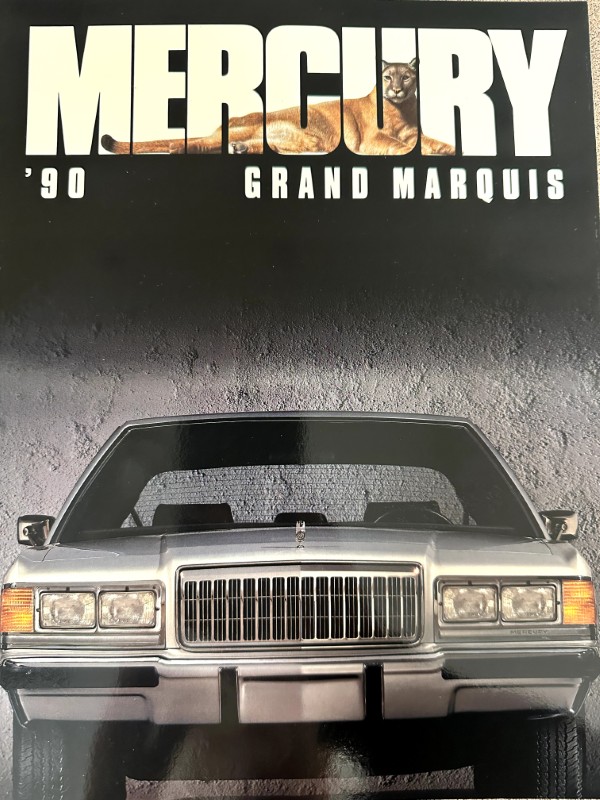 IMG_9101 | Merrick Auto Museum Front view of a silver Mercury Grand Marquis on a poster, with bold 'MERCURY' lettering and '’90 Grand Marquis' text above.