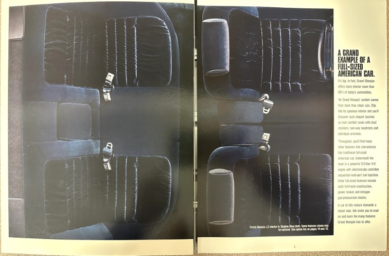 IMG_9102 | Merrick Auto Museum Two-page magazine spread showing dark blue leather car seats (front and rear) with visible seat belts, from a Grand Marquis advertisement.