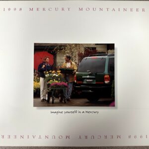 1998 Mercury Mountaineer ad: a couple with a flower cart beside a green SUV; handwritten caption 'Imagine yourself in a Mercury'
