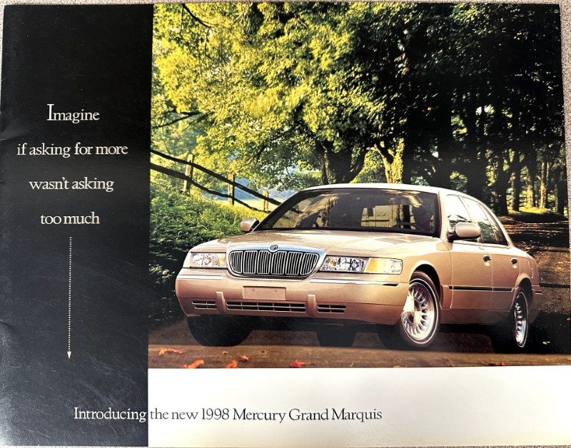 IMG_9128 | Merrick Auto Museum Advertisement showcasing a gold 1998 Mercury Grand Marquis parked on a driveway with trees; left panel reads 'Imagine if asking for more wasn't asking too much'; bottom line announces 'Introducing the new 1998 Mercury Grand Marquis'.