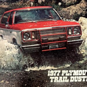 Red 1977 Plymouth Trail Duster driving through a splashy shallow river, front view showing grille and headlights.