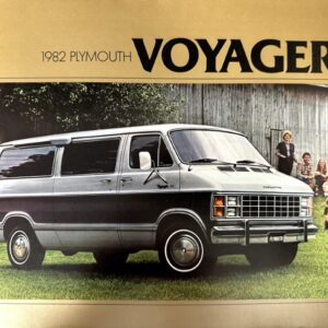 1982 Plymouth Voyager minivan parked on a grassy lawn with a family gathered beside a barn in the background.