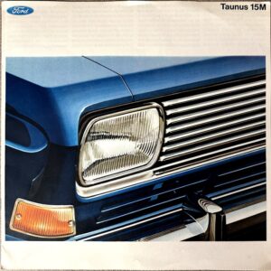 Blue vintage Ford Taunus 15M front end with square headlight, horizontal chrome grille, and orange turn signal below