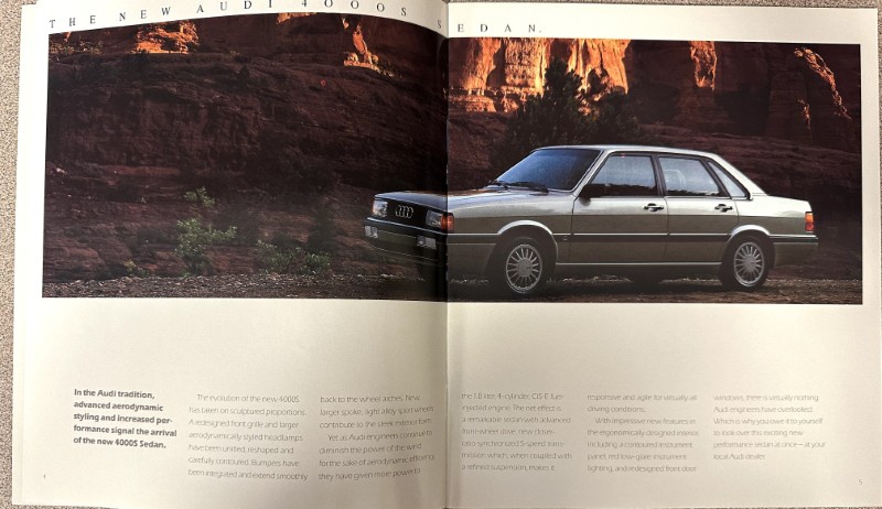 IMG_9341 | Merrick Auto Museum Silver Audi 4000S sedan parked beside red canyon rocks in a two-page auto ad spread.