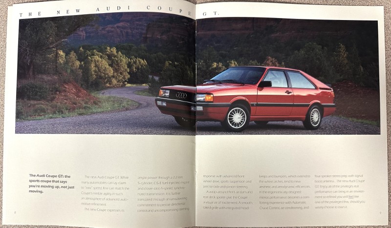 IMG_9342 | Merrick Auto Museum Two-page magazine ad showing a red Audi Coupe GT on a winding road beside a forested landscape, with descriptive text blocks below.