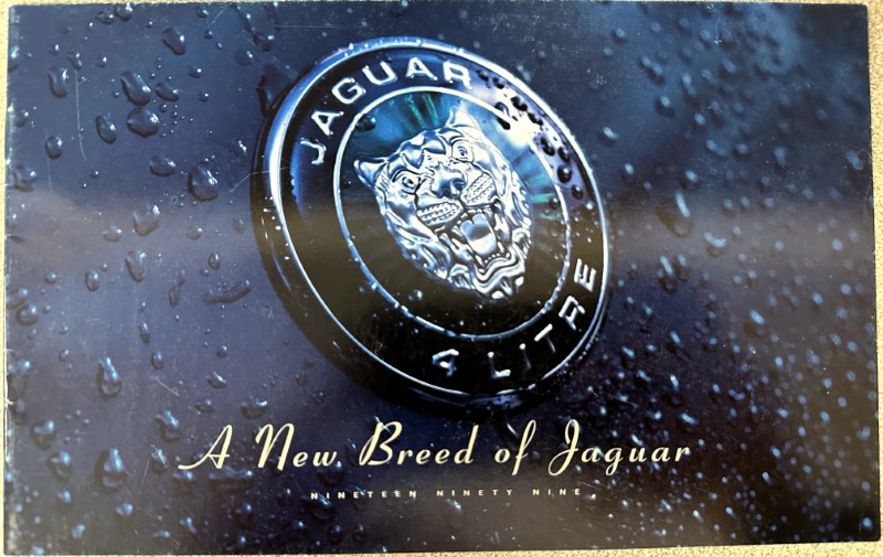 IMG_9347 | Merrick Auto Museum Close-up of a Jaguar badge with the text 'JAGUAR' around the crest and the slogan 'A New Breed of Jaguar' below.