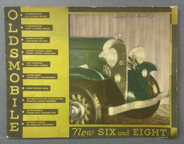 36 Custom | Merrick Auto Museum Vintage Oldsmobile advertisement box showing a green classic car and a tall yellow feature list labeled NEW SIX AND EIGHT on the right side and a handwritten signature at the top edge.