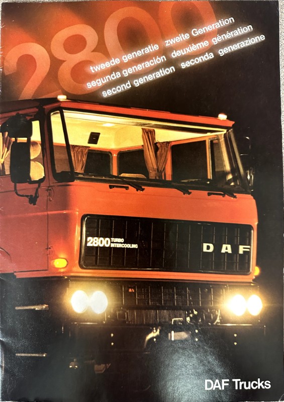 IMG_0016 | Merrick Auto Museum Red DAF truck front view with glowing headlights; badge reads '2800 Turbo Intercooling' and 'DAF' letters appear on grille, night-lights on.