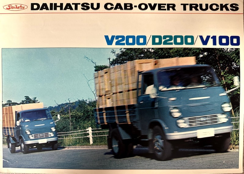 IMG_0045 | Merrick Auto Museum Banner ad for Daihatsu cab-over trucks; two blue trucks carry lumber on a road.