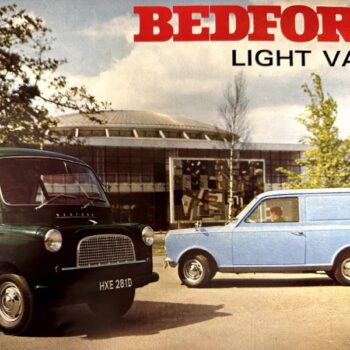 IMG_9588 | Merrick Auto Museum Vintage ad for Bedford light vans showing a dark green van and a light blue panel van in front of a showroom.