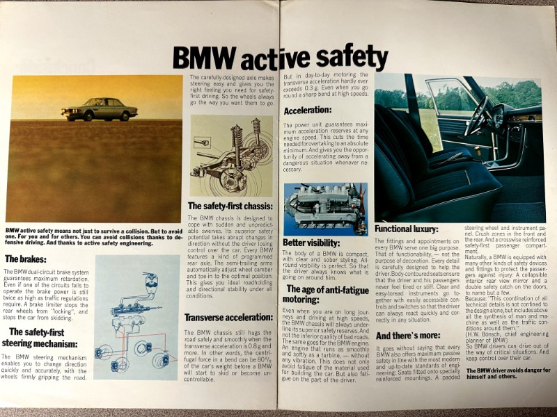 IMG_9654 | Merrick Auto Museum BMW active safety brochure spread: desert car photo with safety diagrams on the left and an interior photo with feature notes on the right (brakes, chassis, visibility, comfort).