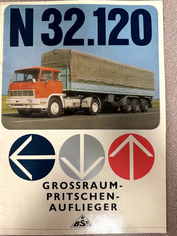 IMG_9774 | Merrick Auto Museum Front cover showing a red cab truck with a long green tarpaulin trailer labeled N 32.120; three circular logos with blue, gray, and red arrows and the German title Grossraum-Pritschenaufleger.