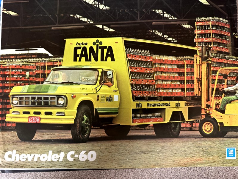 IMG_9880 | Merrick Auto Museum Yellow Chevrolet C-60 delivery truck loaded with stacked Fanta crates in a warehouse, with a forklift nearby and overhead shelving in the background.