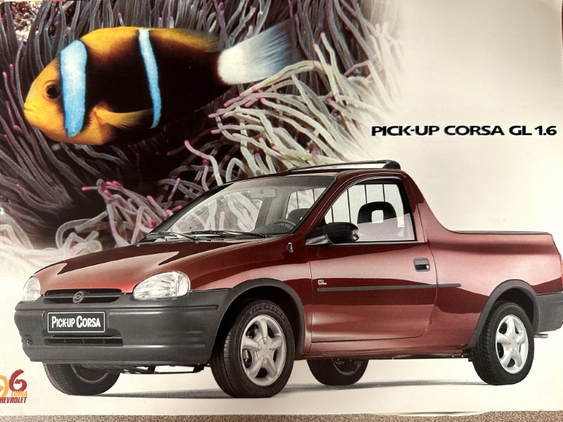 IMG_9898 | Merrick Auto Museum Advertisement image of a red Chevrolet Pick-Up Corsa GL 1.6 shown from the side with a tropical fish backdrop showing a yellow-and-blue fish behind coral, emphasizing the vehicle.